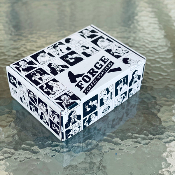 Forge Coffee Roasters Holiday Gift Box with drawn characters drinking coffee on the surfaces of the box