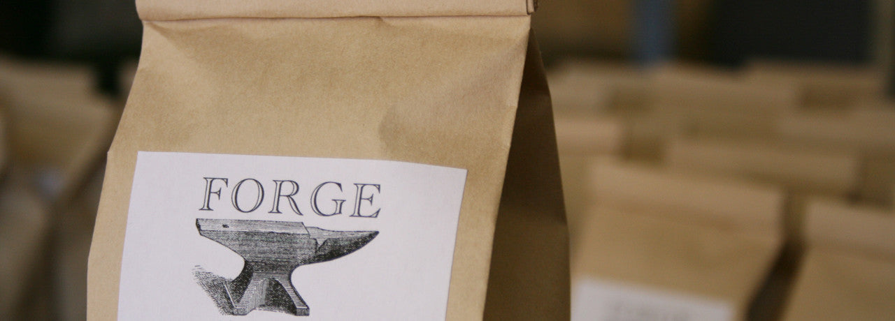 image of bags of coffee, Forge Coffee Logo featured prominently in the forground.
